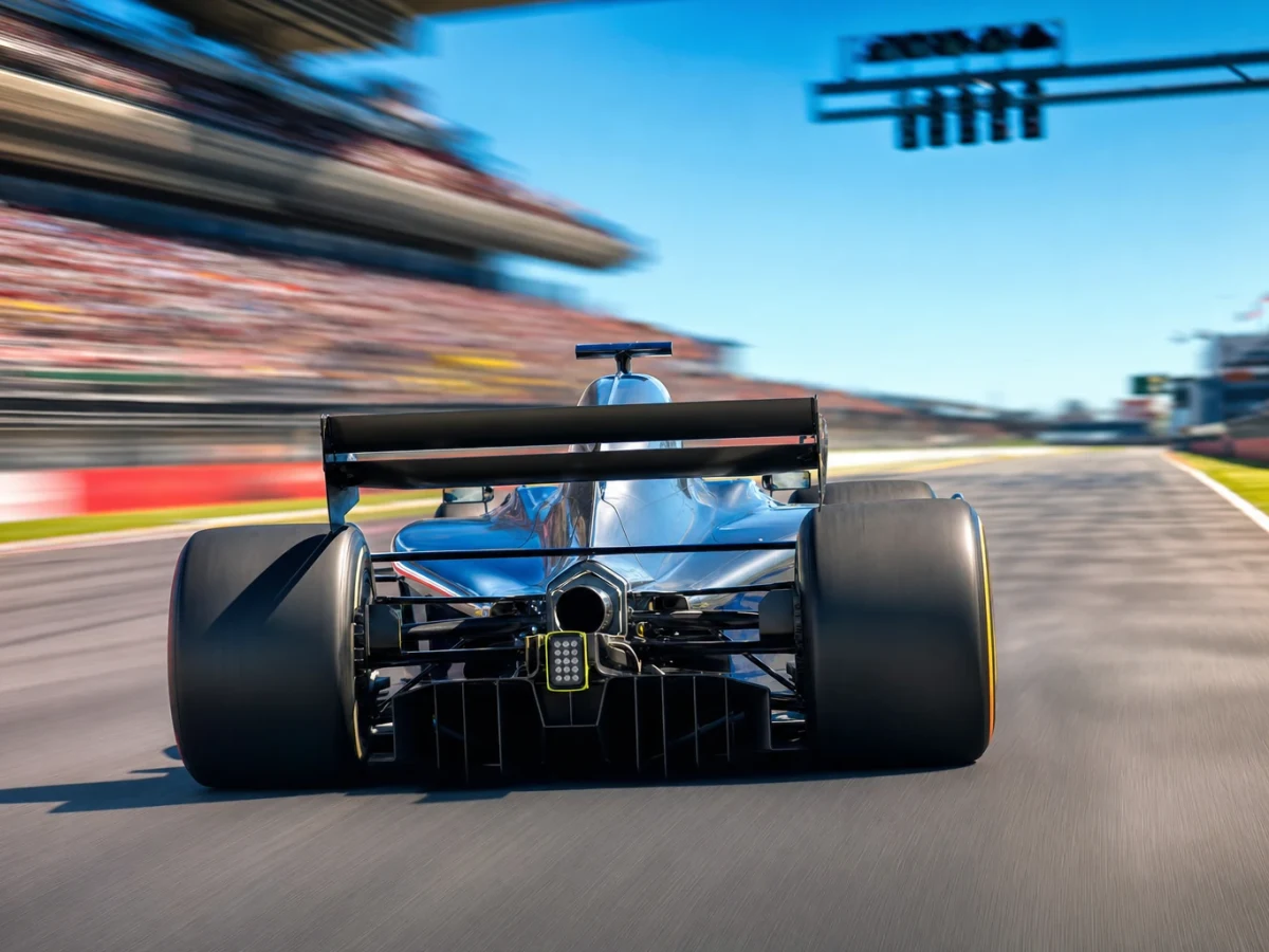 Formel 1-bil med öppnad DRS-bakvinge på en raksträcka.