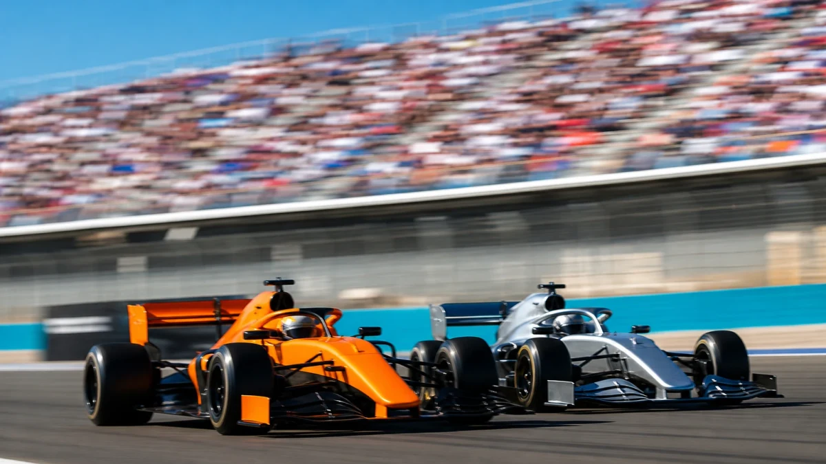 Två formel 1-bilar sida vid sida på en lång raksträcka i hög fart.